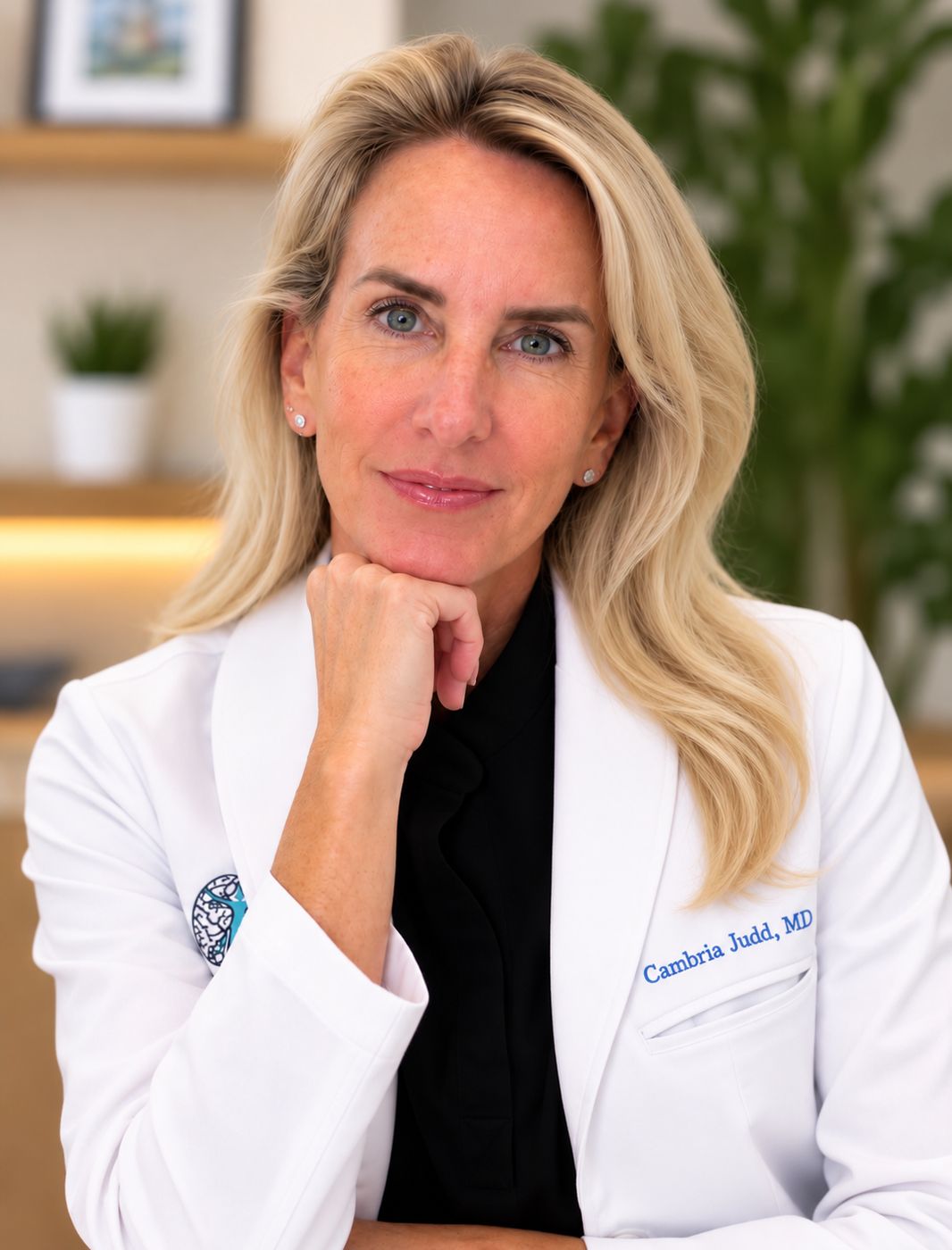Dr. Cambria Judd in a white coat, seated with her chin resting on her hand.